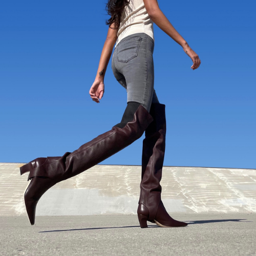 Neil J Rodgers Tik over the knee gaiter designed to be worn with the Tik ankle boot is a stirrup style that attaches over the sole next to the heel. Made of bruciato Italian stretch nappa leather and an elasticized band, the gaiter fits over the knee, and is styled with denim.