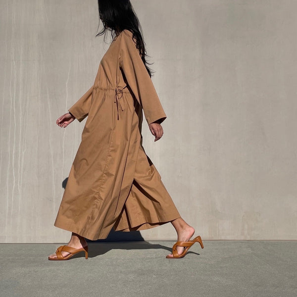 Neil J Rodgers Obi heel with signature padded leather, knotted obi strap sandal with an exaggerated square toe and modern heel in brown nappa leather worn with a camel wide leg jumpsuit.