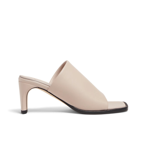 Neil J Rodgers Sue Mule in off white nappa leather has an exaggerated square toe, wide stretch nappa instep strap, padded footbed, and 60mm heel.