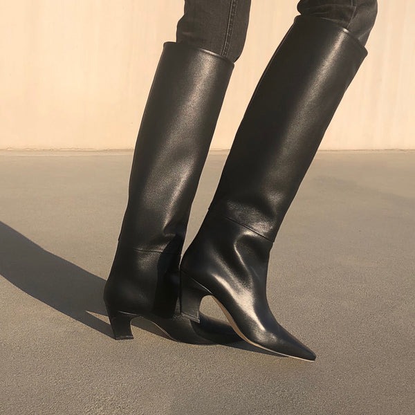 Neil J Rodgers black Meg knee high boots with a pointed square toe made from soft Italian nappa leather paired with black skinny denim.