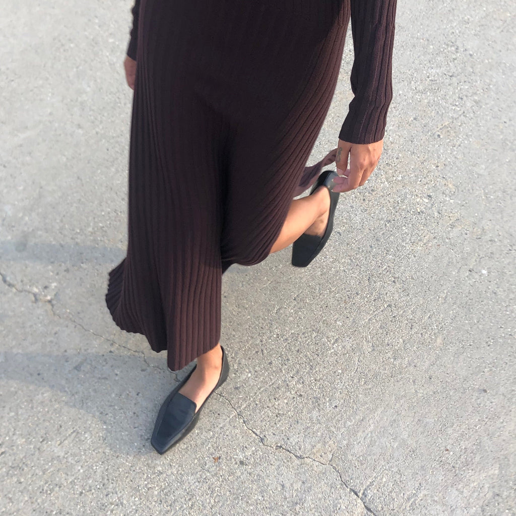 Neil J Rodgers black Liscia loafer with a pointed square toe and minimal stitching in soft Italian nappa leather paired with a brown ribbed sweater dress.