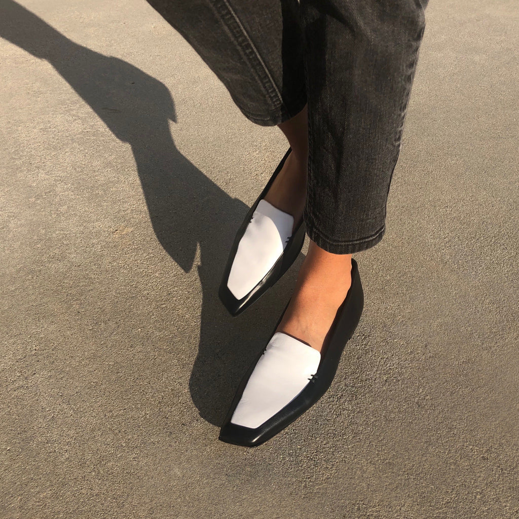 Neil J Rodgers black and white Liscia loafer with a pointed square toe and minimal stitching in soft Italian nappa leather paired with black straight leg denim.