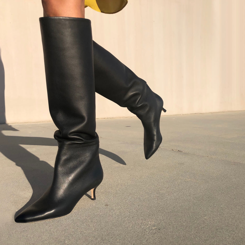 Neil J Rodgers black Eva knee high slouch boot with a 2 inch kitten heel made from Italian nappa leather paired with a mustard yellow silk dress.