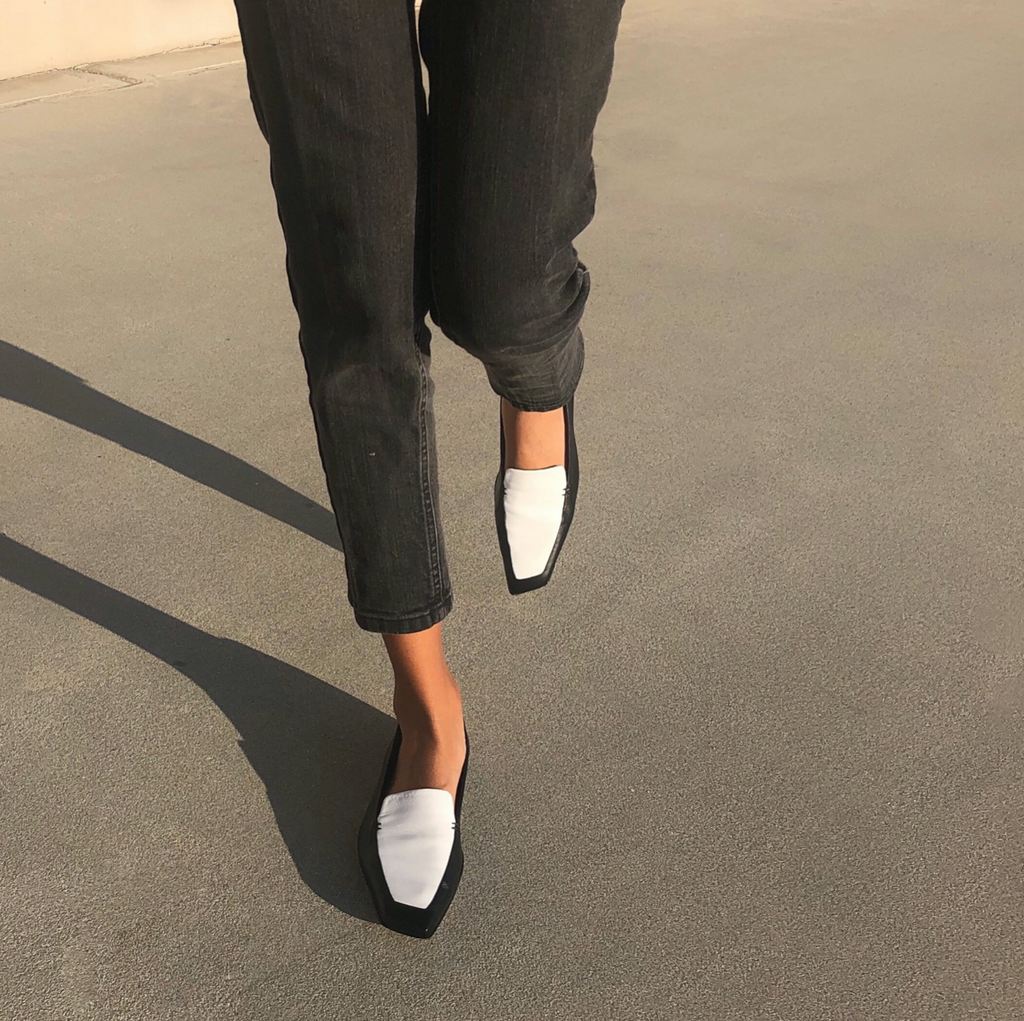 Neil J Rodgers black and white Liscia loafer with a pointed square toe and minimal stitching in soft Italian nappa leather paired with black straight leg denim.